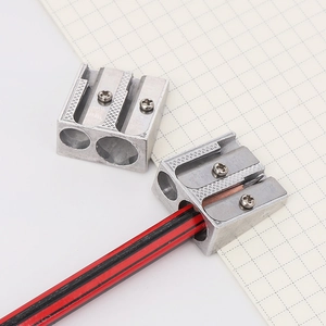 Dual-hole silver aluminum alloy pencil sharpener shown sharpening a striped pencil