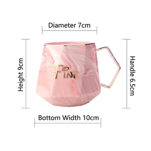 Pink marble ceramic mug with gold handle and geometric design, size dimensions included