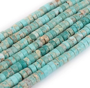 Detail of turquoise colored flat spacer beads with natural brown mineral texture