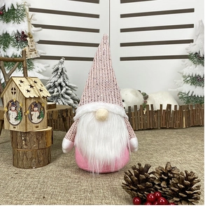 Pink Christmas gnome figurine with sequin hat and white beard in a festive snowy scene