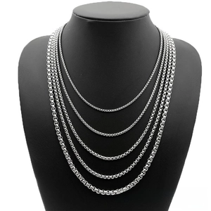 Detail view of five different thicknesses of silver stainless steel chains on black bust
