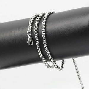 Detail of silver square bead chain necklace with lobster clasp on black leather stand
