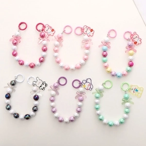 Macro shot of assorted luminous beaded phone chains with cute cartoon animal charms