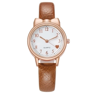 Detail of rose gold cat ear watch with brown leather strap and red heart on the dial