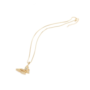 Macro detail of gold copper necklace featuring a butterfly pendant with colorful gemstones
