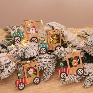 Christmas wooden train ornaments set with Santa, snowman and deer hanging on a snowy tree