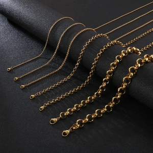 Polished gold stainless steel O-link chains in various sizes on textured black background