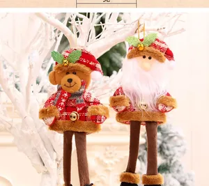Detail of Christmas plush pendants with long legs featuring Santa and a bear on a branch