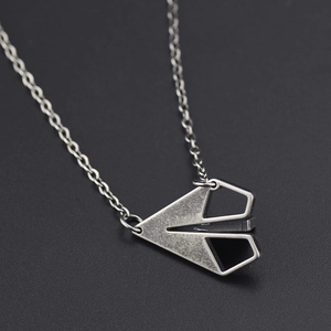 Collier minimaliste avec pendentif avion en papier en titane sur un fond noir élégant