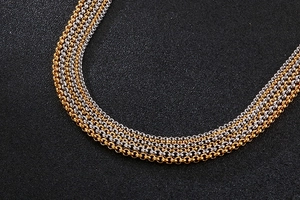 Detailed close-up of multi-layer stainless steel O-link necklace in gold and silver finish