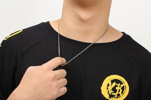 Detail of silver 304 stainless steel chain necklace worn by male model on black t-shirt