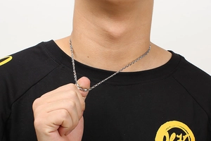 Detail of silver stainless steel cross chain necklace on neck with close-up shot