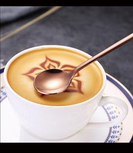 Close-up of a rose gold 304 stainless steel coffee spoon on a latte with foam art