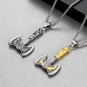 Detail showing silver and gold Viking double-headed axe pendants with intricate engravings