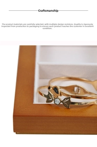Detail of a slim gold bracelet with elegant butterfly and flower shell inlays in a wood box
