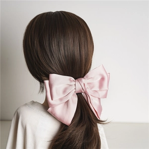 Pink satin bow hair clip for women featuring a large three-layer ribbon design