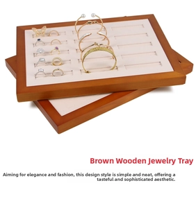 Close-up of dual-layer wooden jewelry trays with beige velvet slots for rings and bracelets