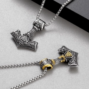 Detail of silver and gold stainless steel Viking Mjolnir pendants with Valknut symbols