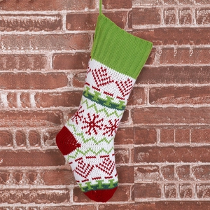 Close-up of snowflake pattern on a high-quality knitted Christmas stocking with red brick background