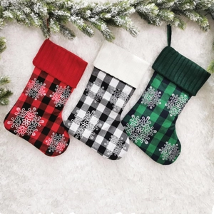 Three 18-inch plaid Christmas stockings with white snowflake patterns on plush background