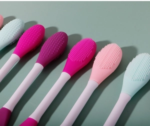 Close-up of dual-ended silicone facial masks brushes in pink, purple, and blue tones