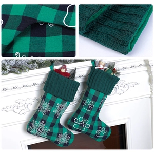 Detail of green plaid Christmas stockings with embroidered snowflake and paw prints hanging