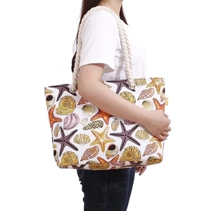 Women's beach tote bag with starfish pattern and thick rope handles worn by model