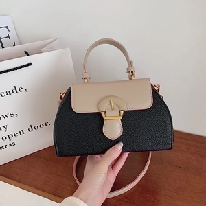 Close-up of color-block handbag with lychee texture leather and vintage gold buckle