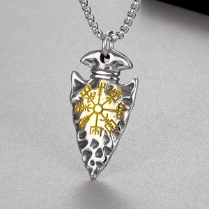 Close-up of arrow-shaped titanium pendant with golden Viking Vegvisir symbol and hammered texture