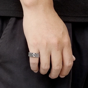 Close-up of a Gothic skull ring in vintage silver finish on a male finger