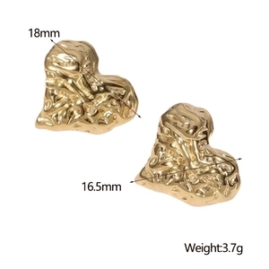 Macro detail of gold irregular heart stud earrings with size measurements and weights
