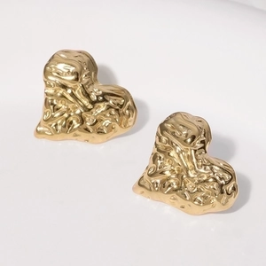 Close-up of golden heart-shaped stainless steel earrings with unique wrinkled texture