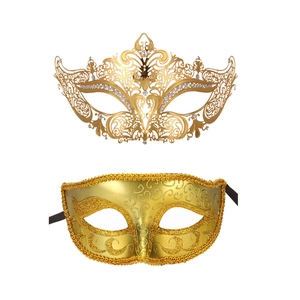 Close-up of two ornate gold masquerade masks with filigree diamonds and glitter patterns