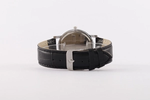 Rear view of silver men's watch case and black faux leather strap with buckle closure