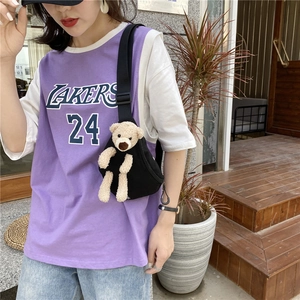 Sac bandoulière en toile noire avec un ours en peluche mignon porté à l'extérieur
