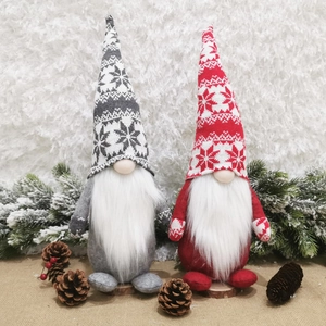 Detail of grey and red Christmas gnomes with knit hats and faux fur beards on snow background