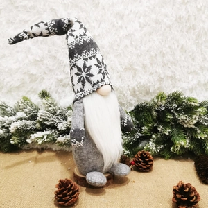 Nordic Christmas Gnome figurine with gray knitted snowflake hat on a rustic wooden base