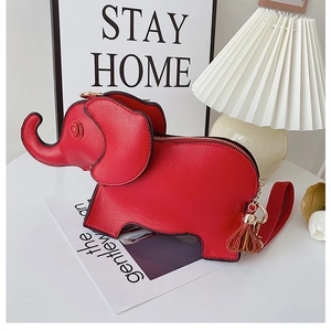 Detail of red elephant-shaped leather handbag with gold zipper and tassel decoration