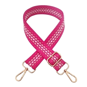Detail of adjustable woven handbag strap in rose pink with luxury gold metal clasps