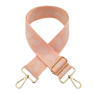 Detail of pink geometric woven bag strap with adjustable gold buckle and metal swivel hooks