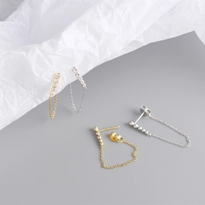 Macro detail of S925 silver chain earrings with rows of zircon and gold plating