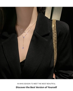 Dettaglio della collana a doppio strato in titanio dorato con ciondolo a Y su modella