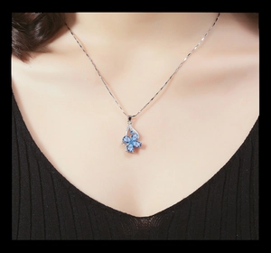 Close-up of blue butterfly pendant with water drop stones on a silver chain