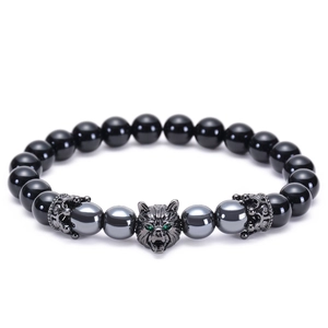 Macro shot of a black agate beaded bracelet with a silver wolf head and crown charms