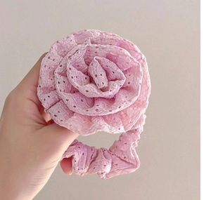 Close-up of pink lace rose scrunchie featuring intricate hollowed floral patterns