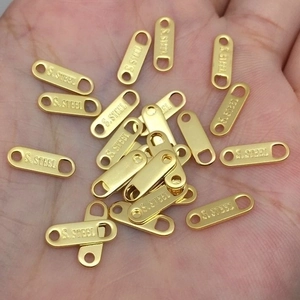 Macro view of gold-plated stainless steel tags with S.STEEL engraving for DIY jewelry