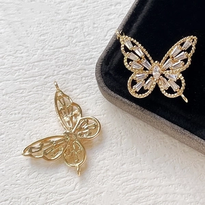 Macro detail of gold butterfly pendants with inlaid zircons for DIY jewelry making