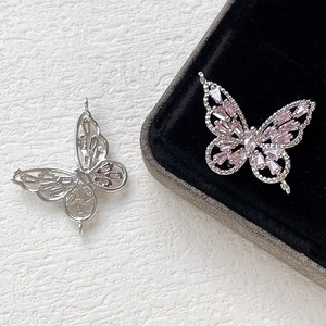 Detailed view of silver butterfly charms with pink zircon inlay for DIY jewelry making