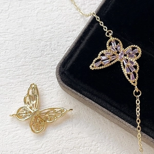 Macro shot of 14k gold-filled butterfly pendant with purple zircon for jewelry making