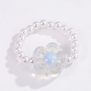 Close-up of white beaded ring featuring an iridescent glass flower charm for women